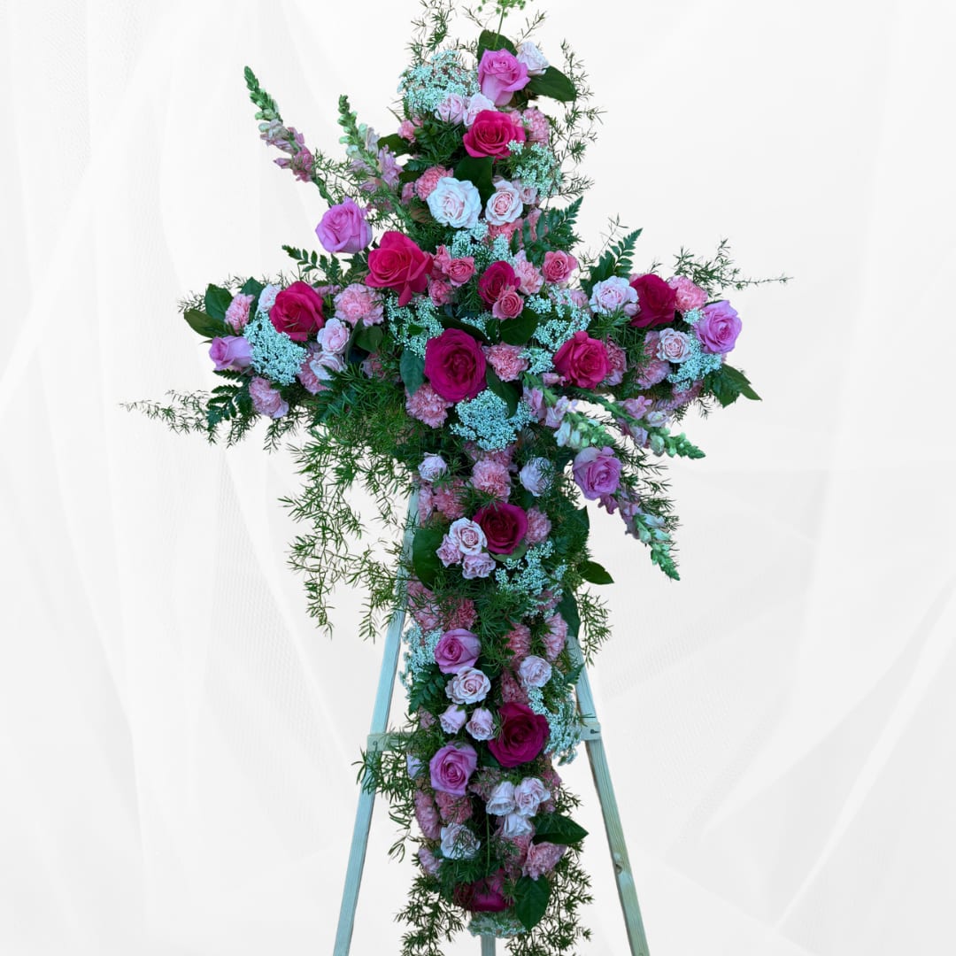Large pink and white floral cross on a stand