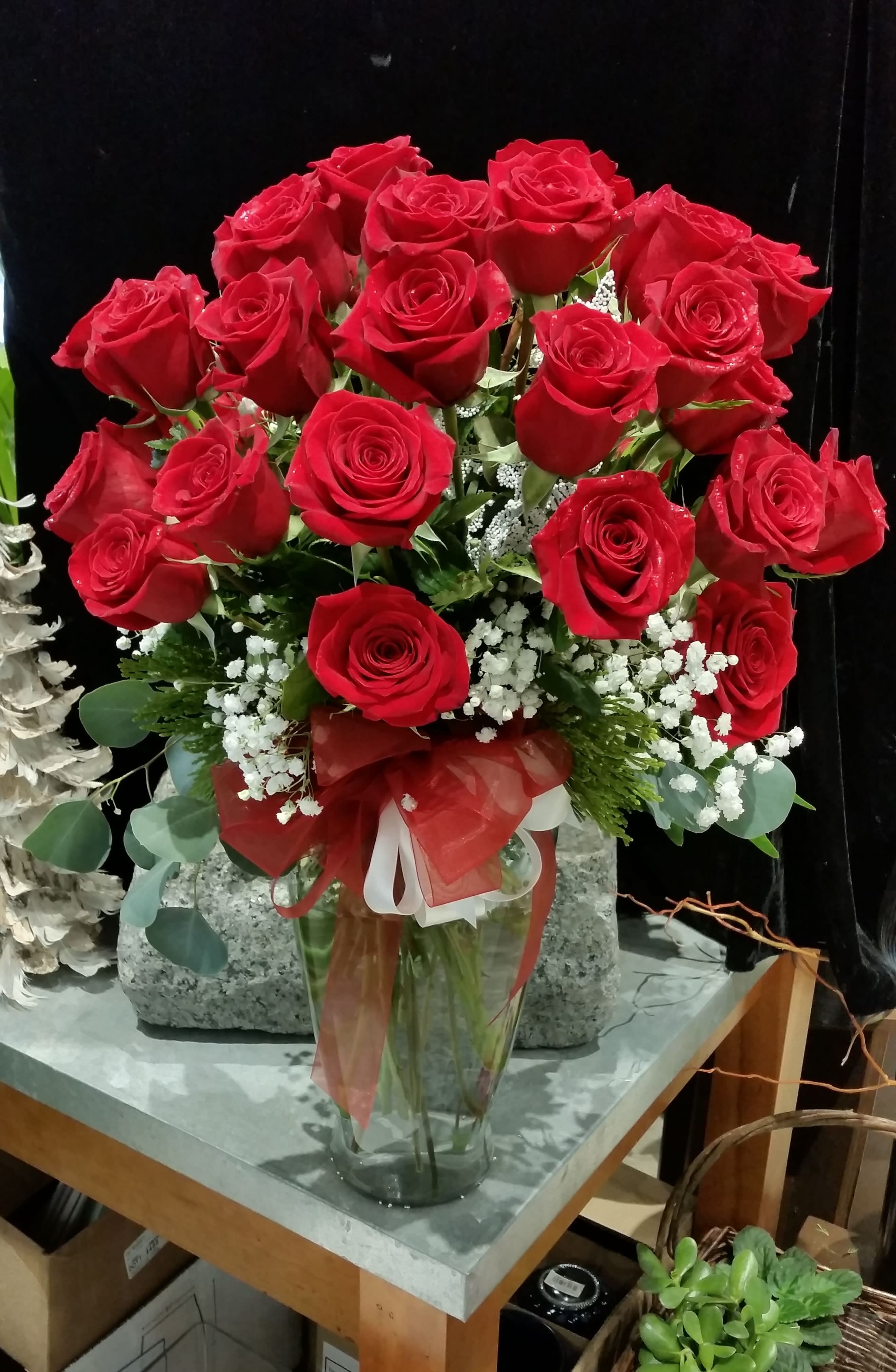 Bouquet of red roses in a glass vase with a red ribbon