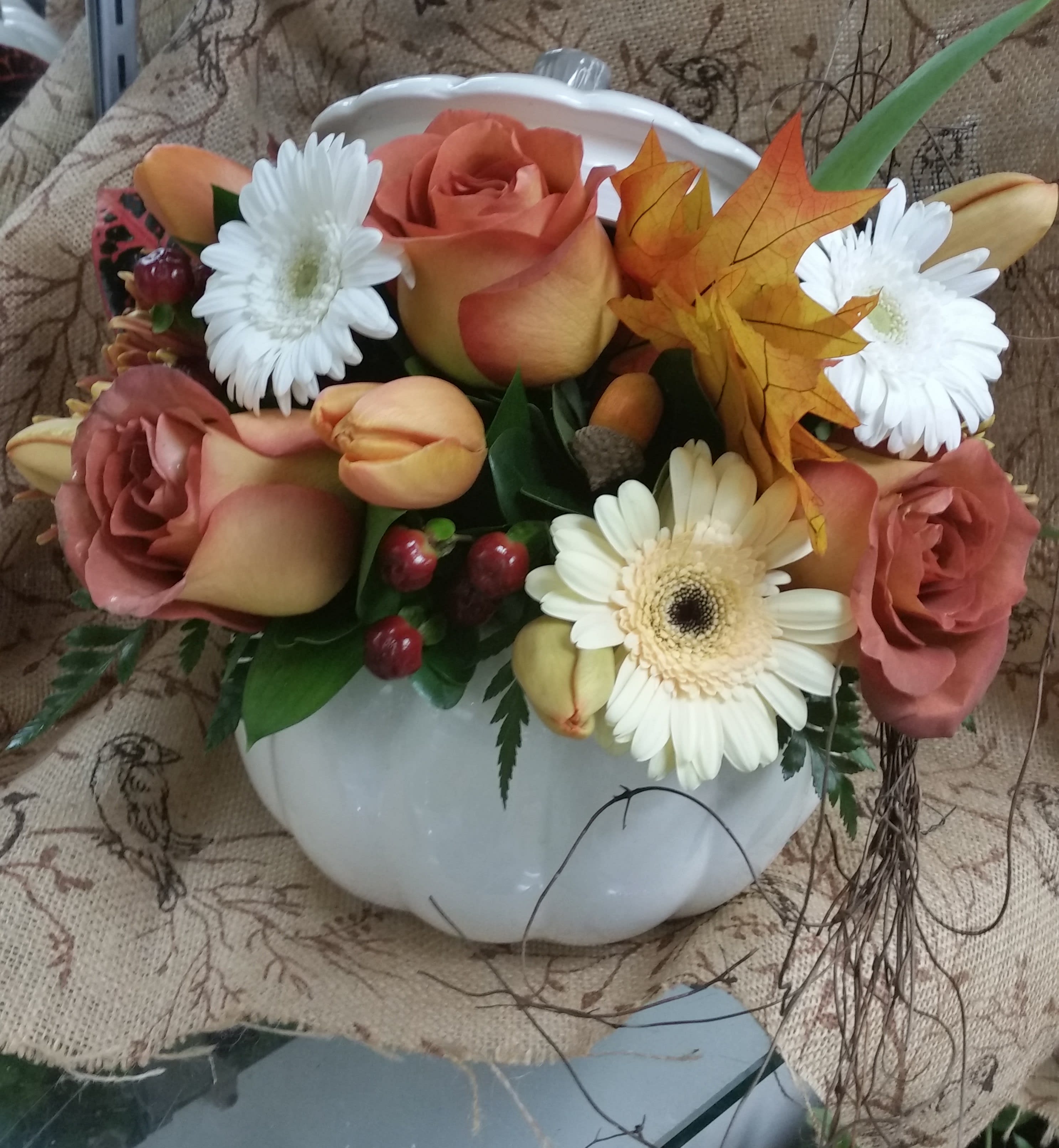 Mixed bouquet in a white pumpkin-shaped vase with roses and daisies