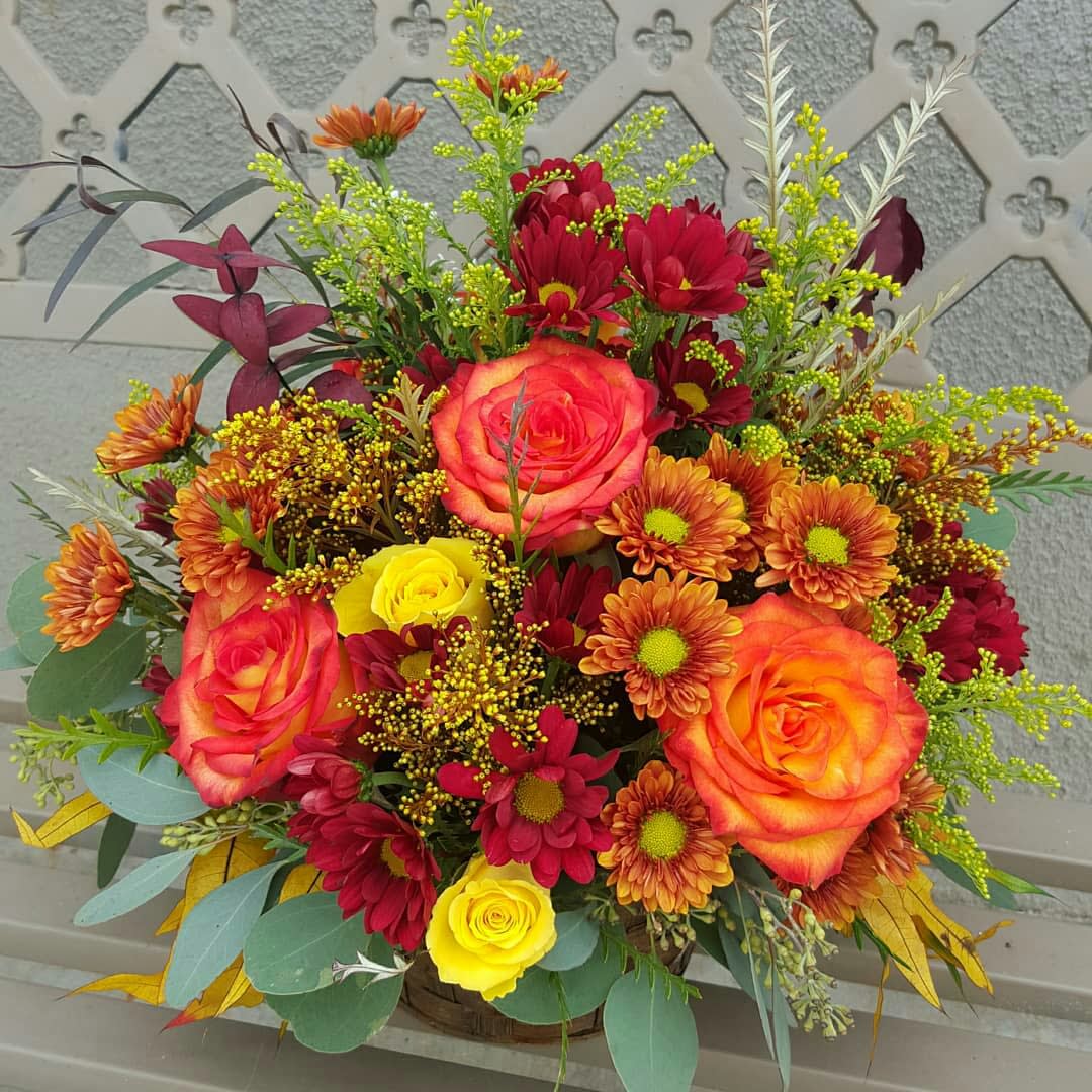 Mixed bouquet of roses and daisies in a basket
