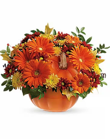 Orange pumpkin-shaped vase with orange and yellow flowers