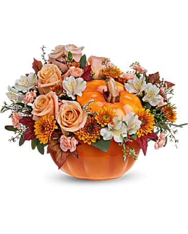 Pumpkin-shaped vase with peach roses and autumn flowers
