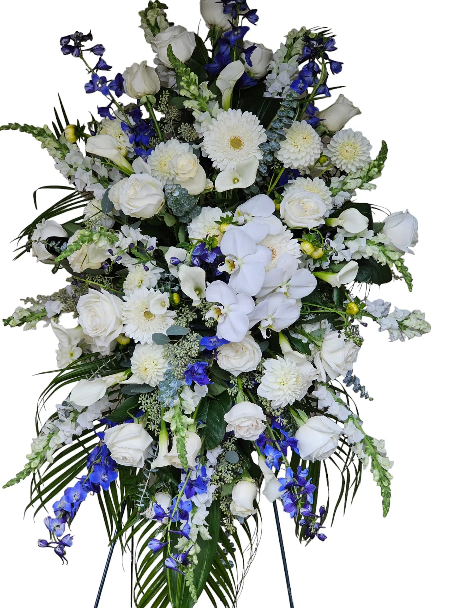 Tall white and blue funeral spray with roses, orchids, and daisies