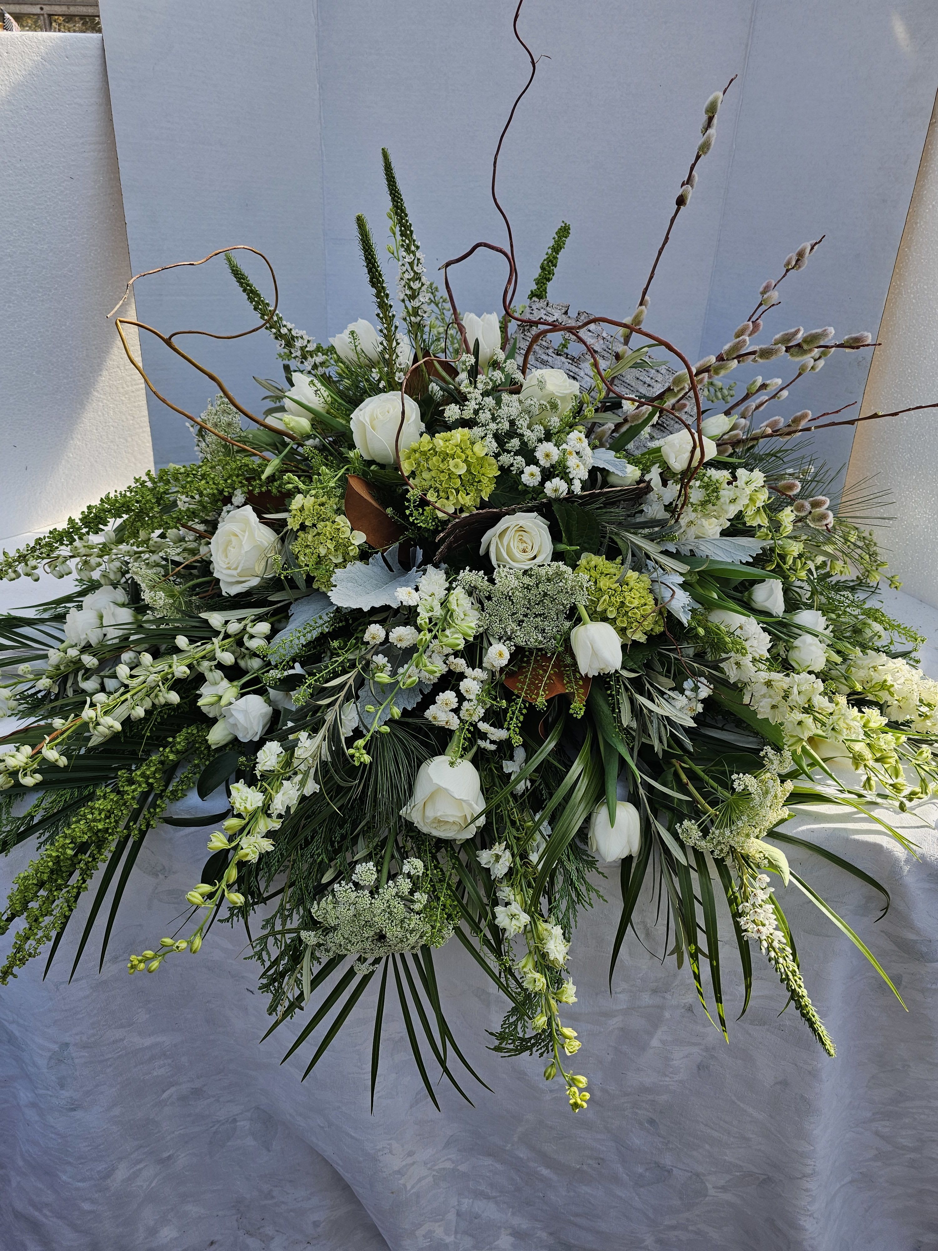 Large white floral spray with roses and mixed greenery