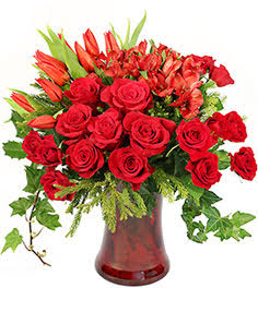Red roses and orange lilies in a red glass vase