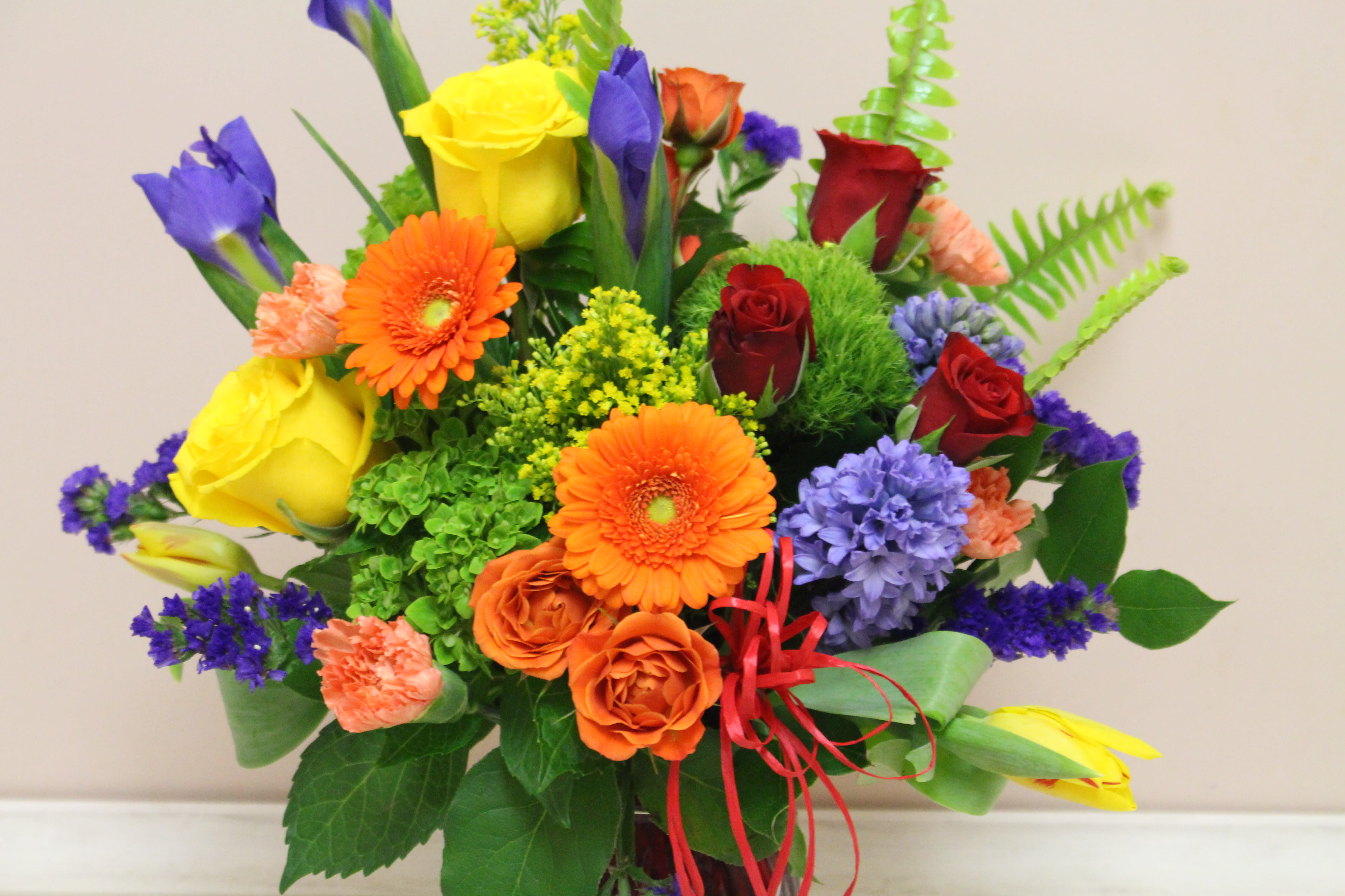 Colorful mixed bouquet with roses, gerbera daisies, and purple blooms