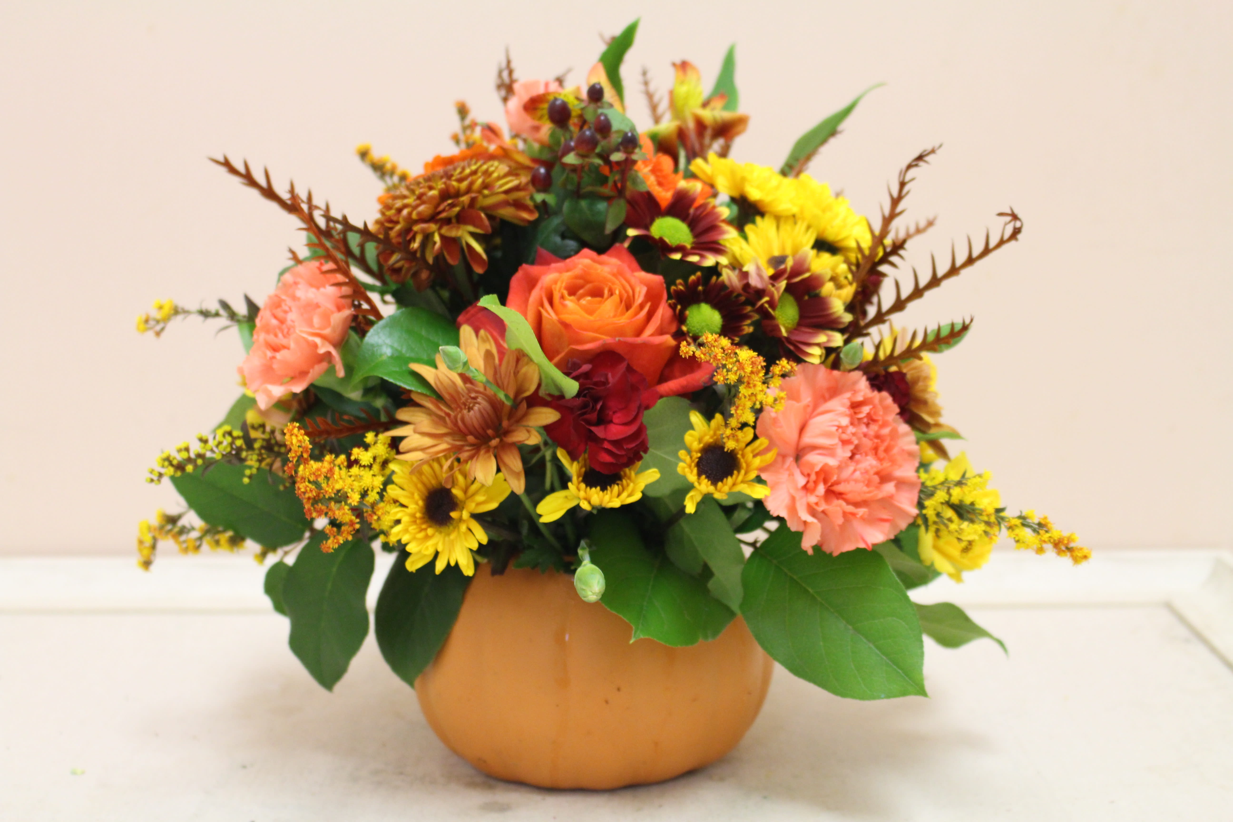 pumpkin patch  - This terra cotta pumpkin is full of roses, poms, spray roses, and gerbera daisy.  The pumpkin container can be used for multiple purposes when you are through with the flowers