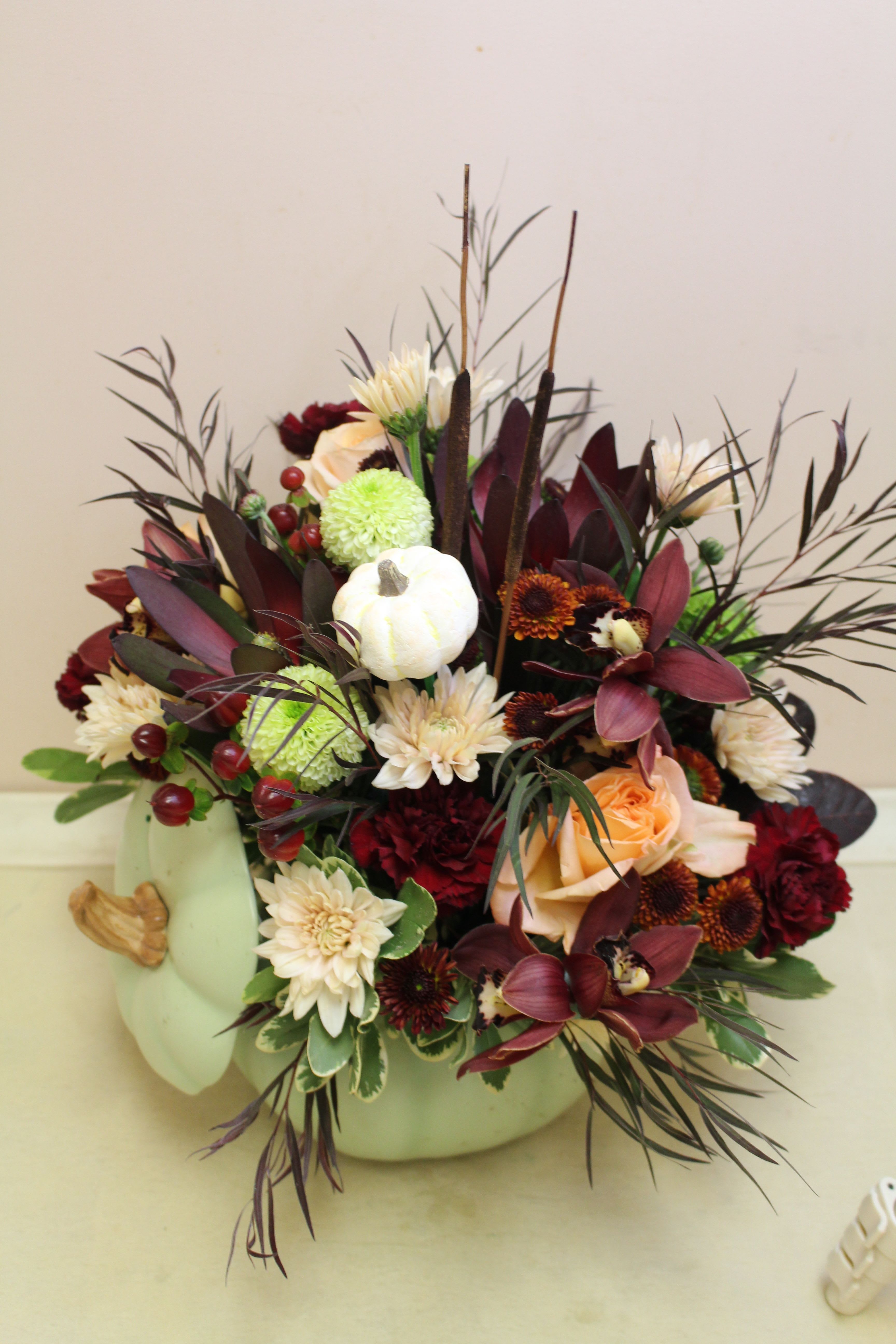 Sage's Harvest Pumpkin - Bring autumn's charm to your table with Sage Harvest Bouquet, a delightful centerpiece adorned with rustic elegance. Nestled in a timeless hand-painted ceramic pumpkin, its exquisite details and warm, earthy hues create a captivating focal point. The perfect blend of autumn hues and floral elegance for any occasion. 