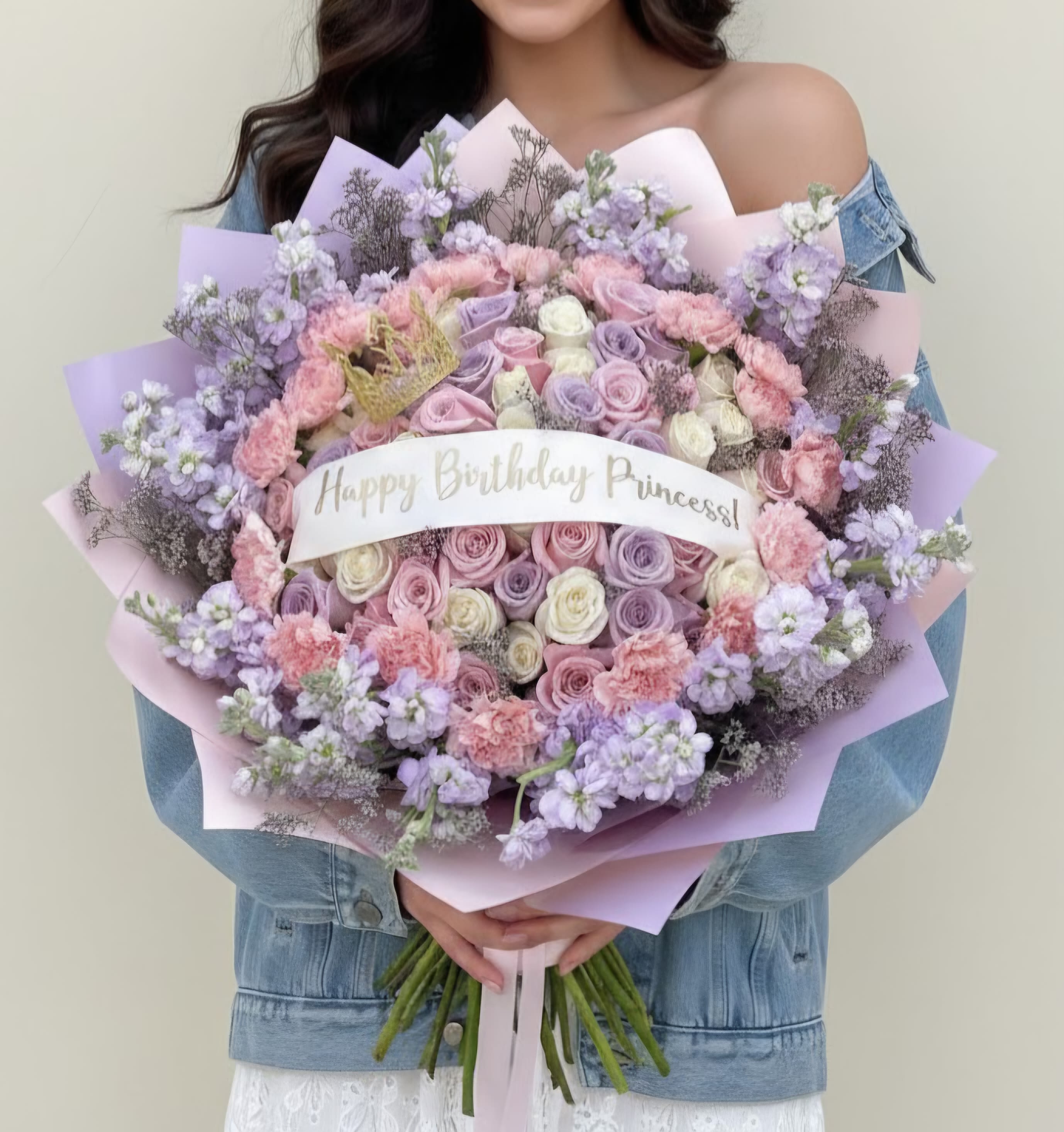 Large pastel bouquet of roses, carnations, and lilac flowers with a birthday ribbon