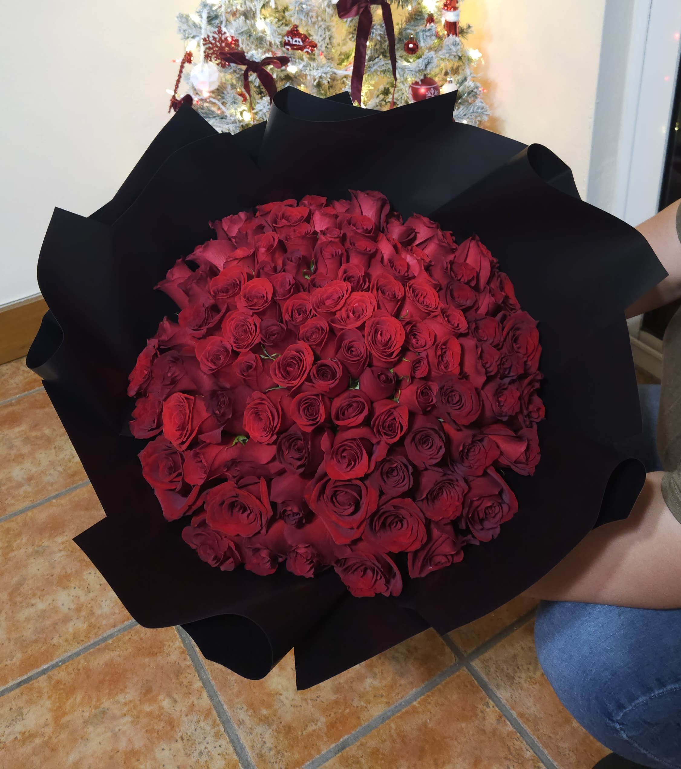 Large bouquet of red roses wrapped in black paper