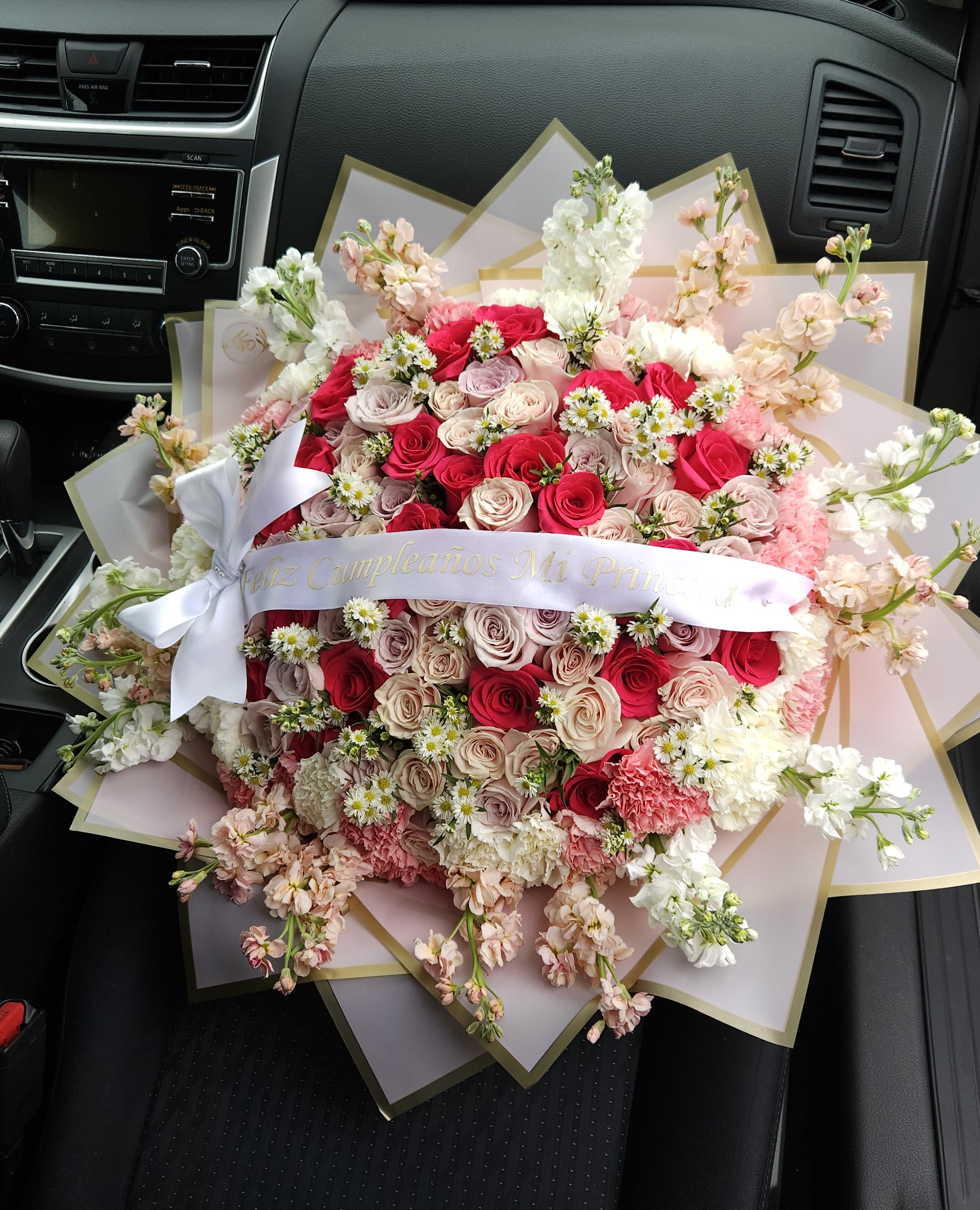 Large bouquet of pink and white roses with small white daisies