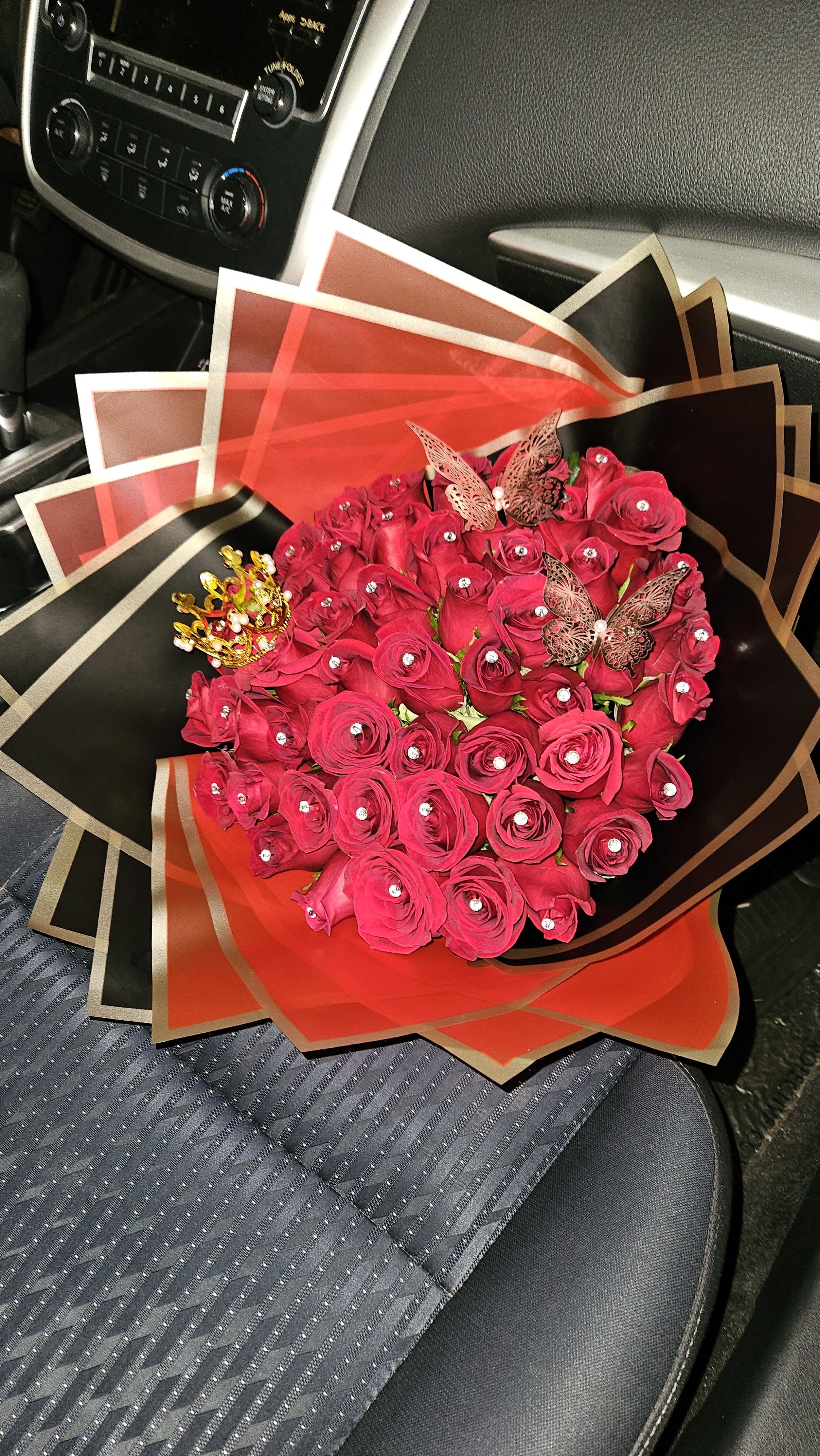 Bouquet of red roses with decorative butterflies and a crown wrap