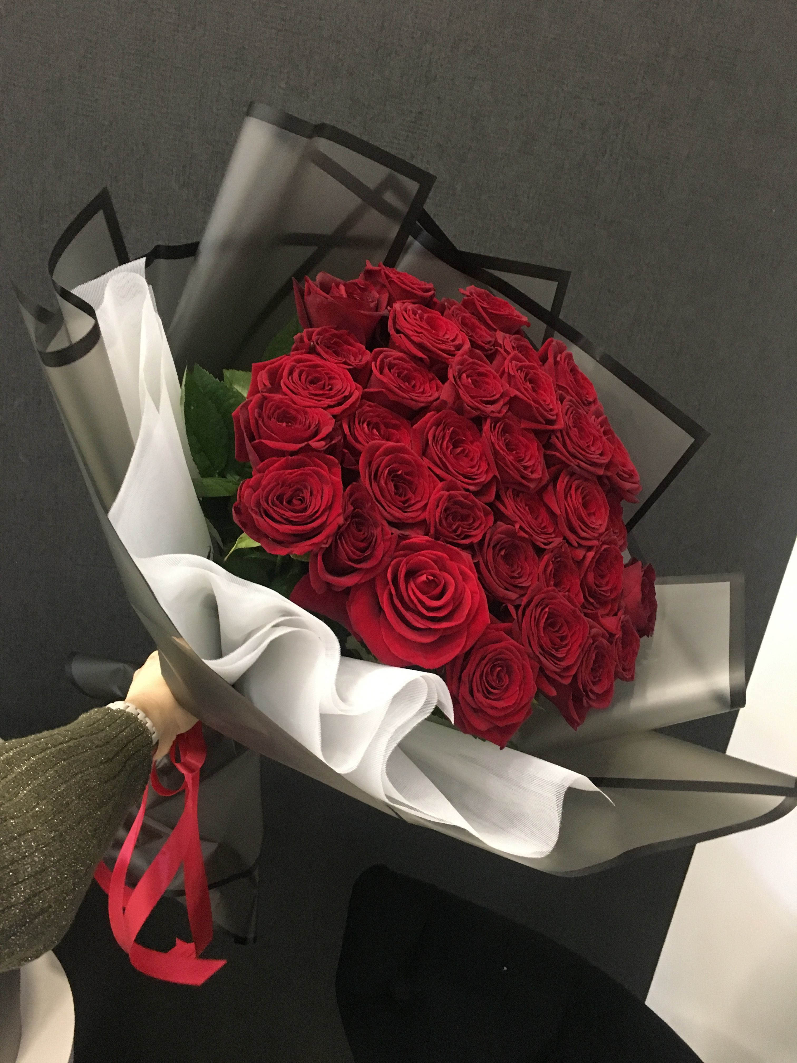 Bouquet of red roses wrapped in black and white paper
