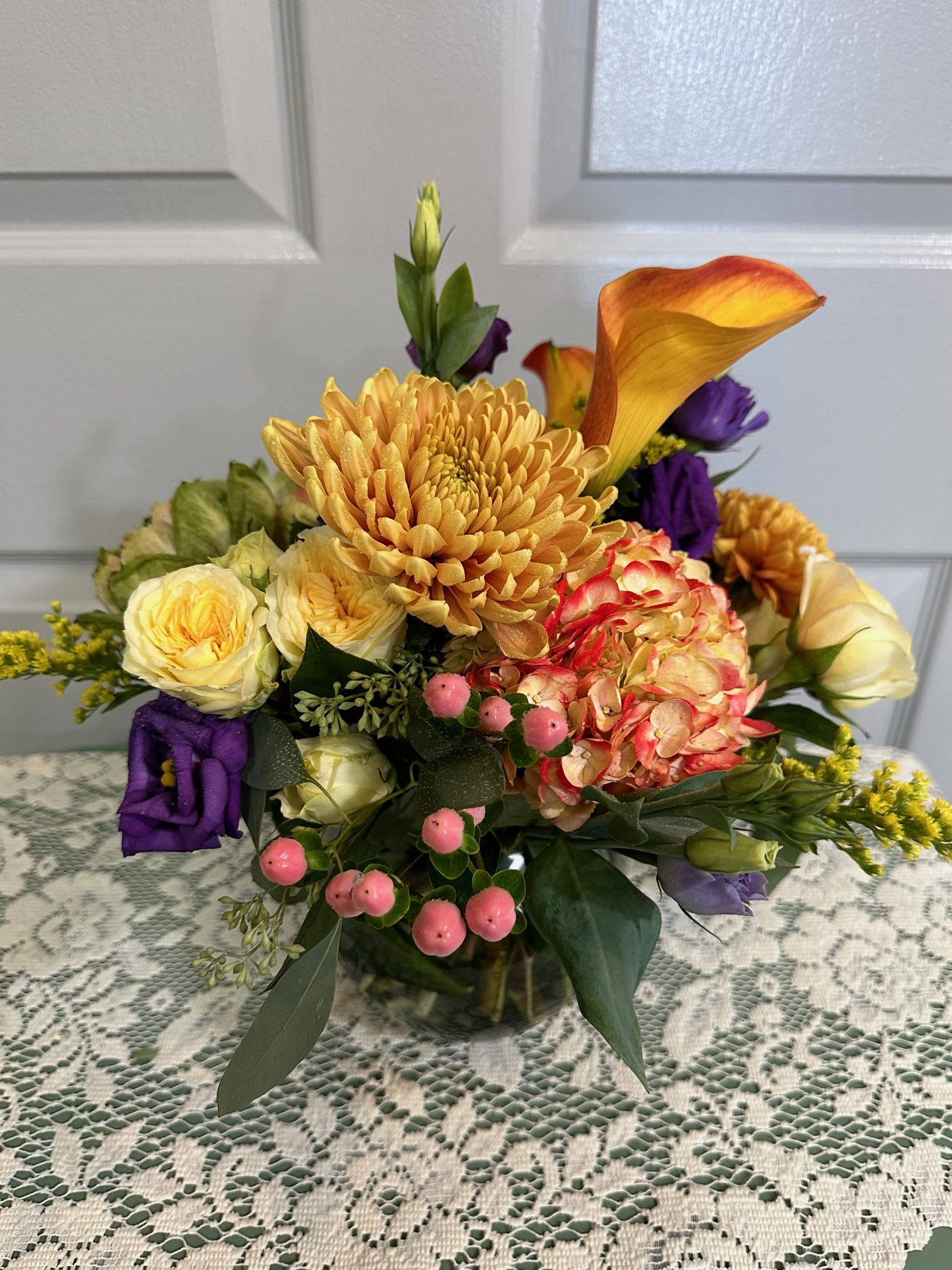Mixed bouquet with orange calla lilies, chrysanthemums, roses, and pink berries