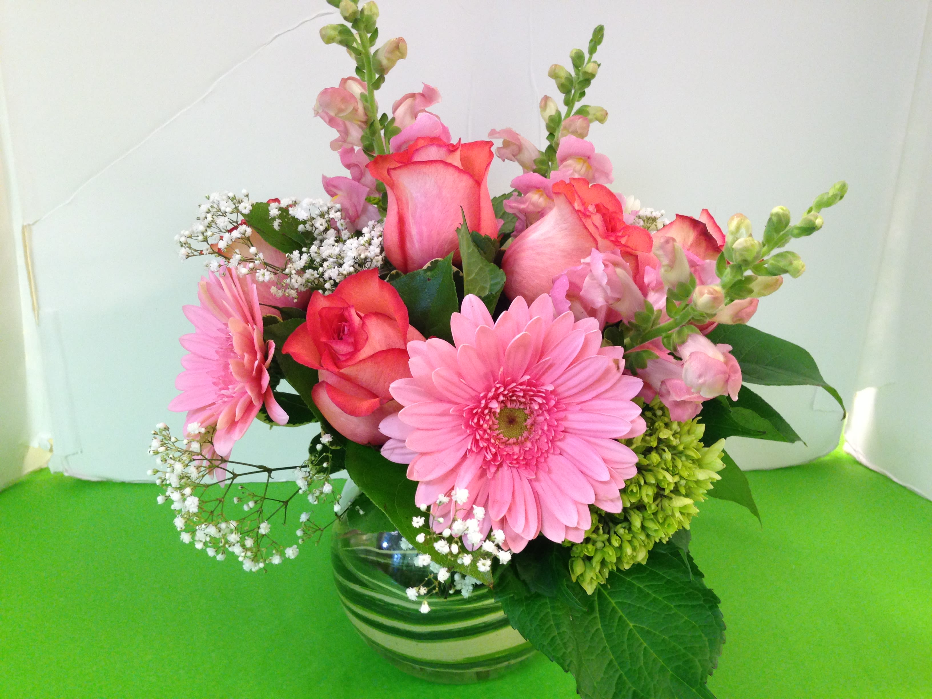 Pink roses and gerbera daisies in a glass vase