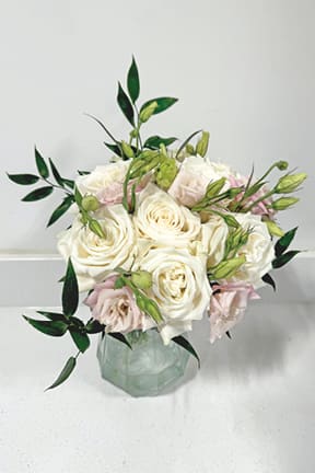 White and blush roses arranged in a glass vase