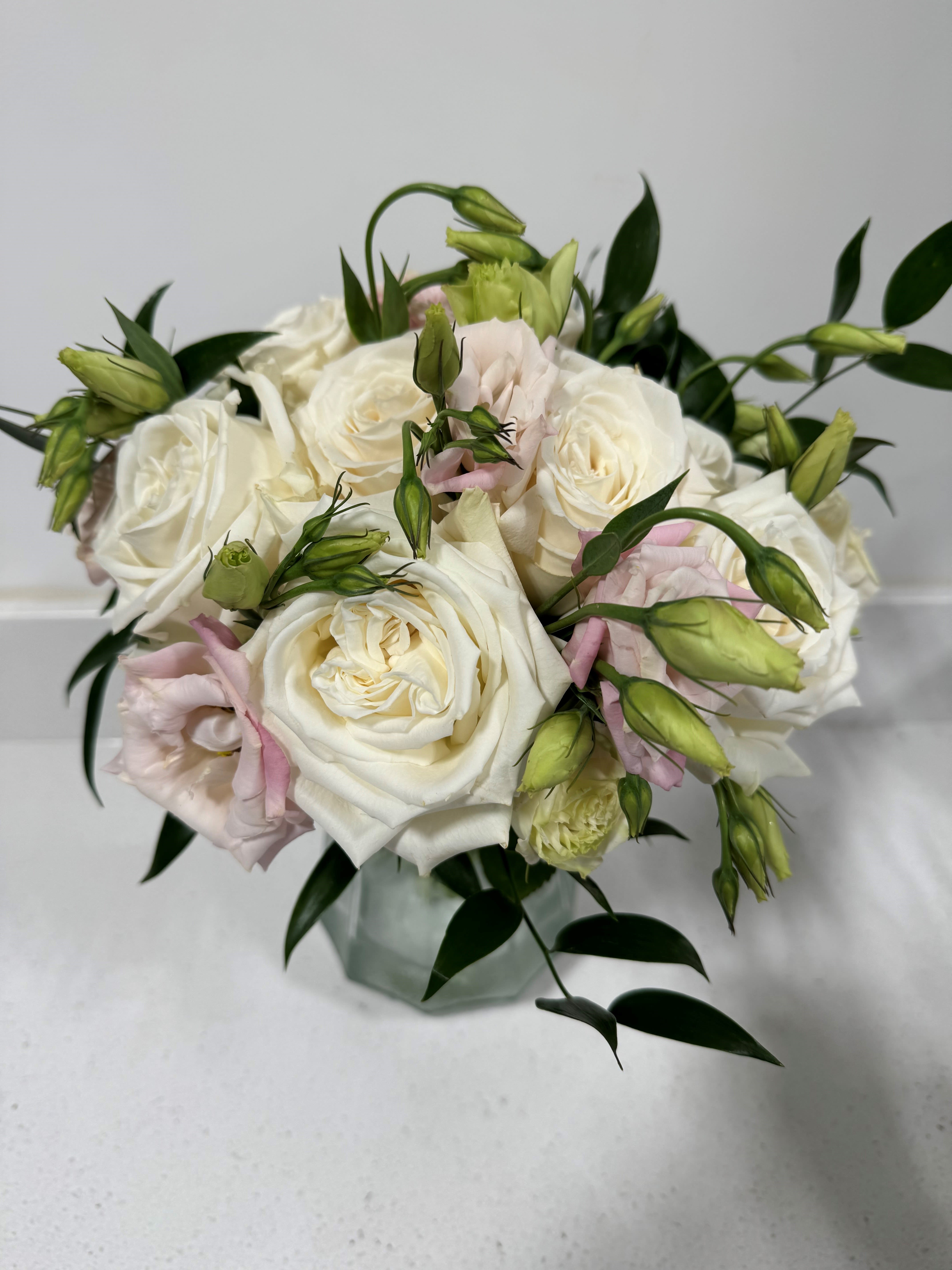 White and blush rose bouquet in a glass vase
