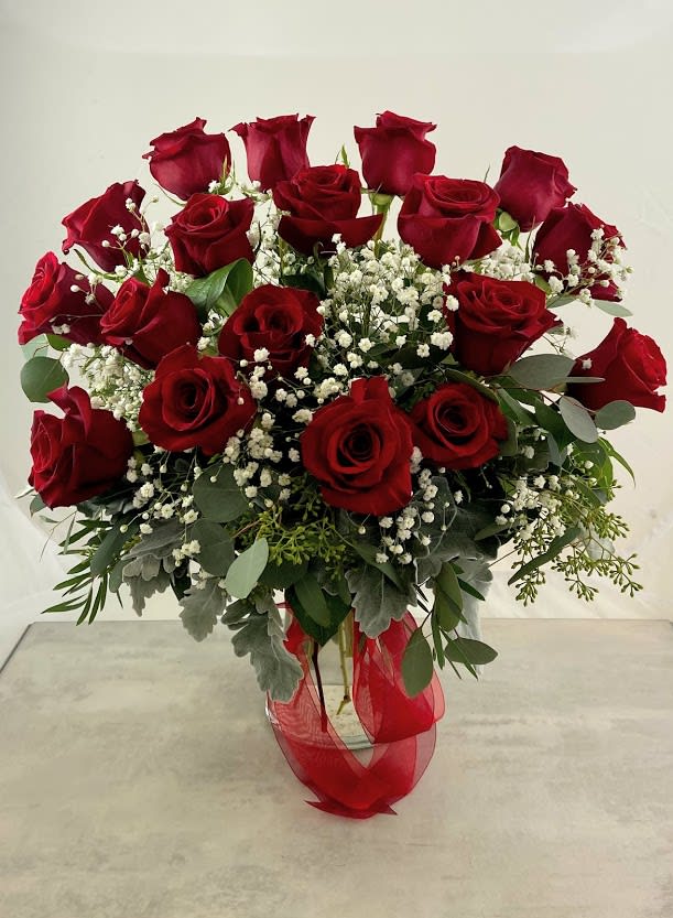Bouquet of red roses with baby's breath in a glass vase
