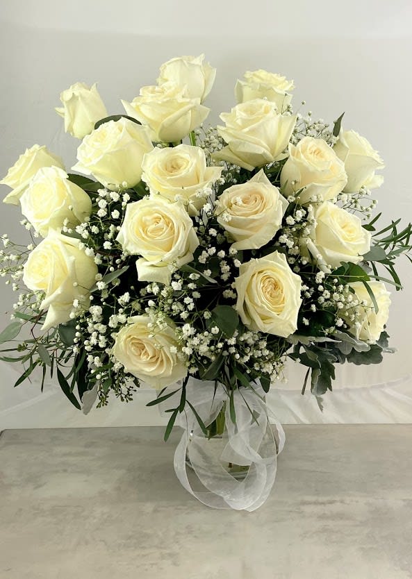 Bouquet of cream roses with baby's breath in a glass vase