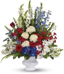 Red, white, and blue floral arrangement in a white vase