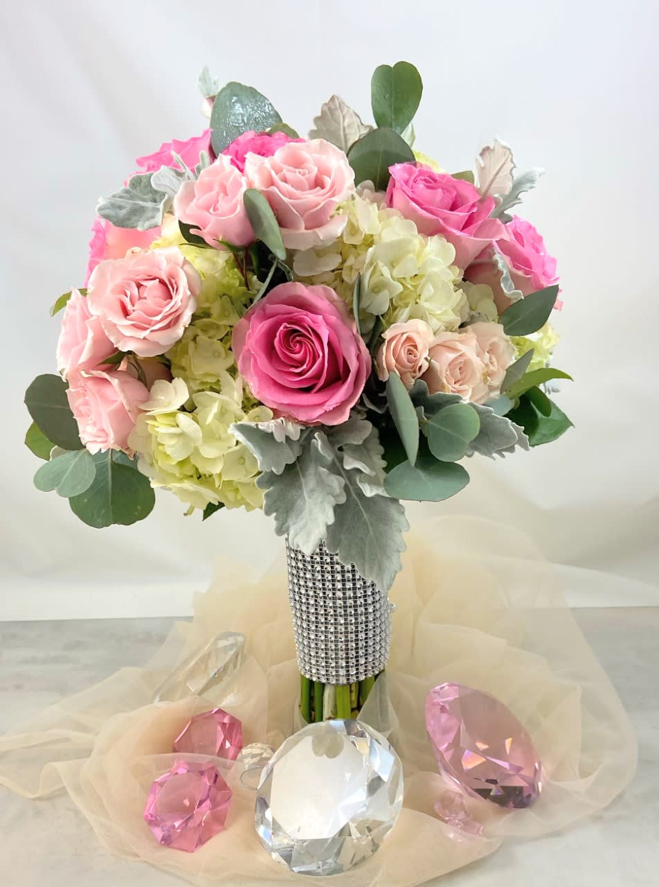 Pink and blush roses arranged in a jeweled bouquet with pale hydrangeas