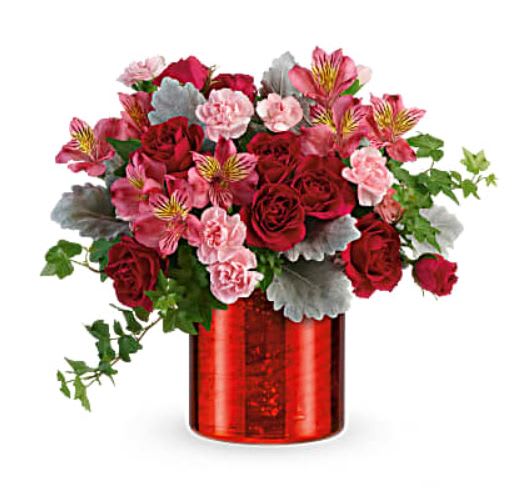 Red and pink flower arrangement in a red glass vase