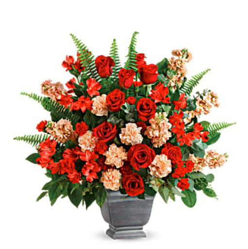 Bold Tribute - Bold and beautiful, this majestic mix of red roses and fresh greens in a large, stone-inspired pot is a show of strength and support.  •Red roses, red alstroemeria, carnations, miniature red carnations, and peach stock are arranged with spiral eucalyptus, seeded eucalyptus, sword fern, and lemon leaf.  •Delivered in Teleflora's Modern Heritage pot.  •Orientation: One-Sided 