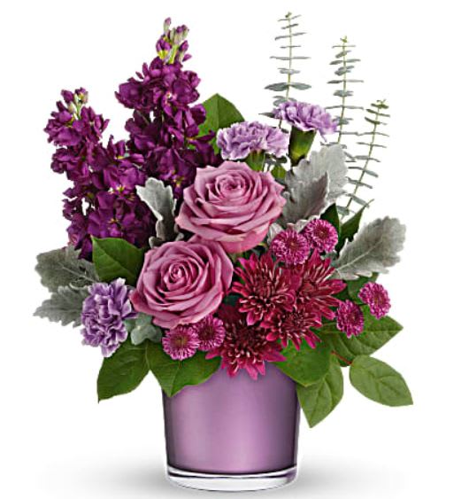 Purple and pink flower arrangement in a lavender vase