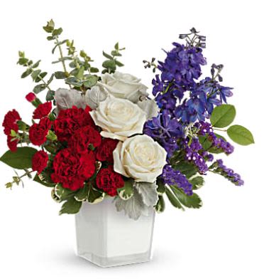 Bouquet of red and white roses with purple flowers in a clear vase