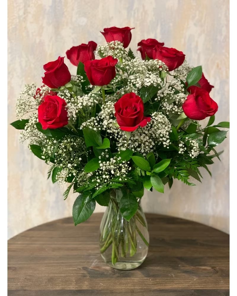 Red roses with baby's breath in a clear glass vase