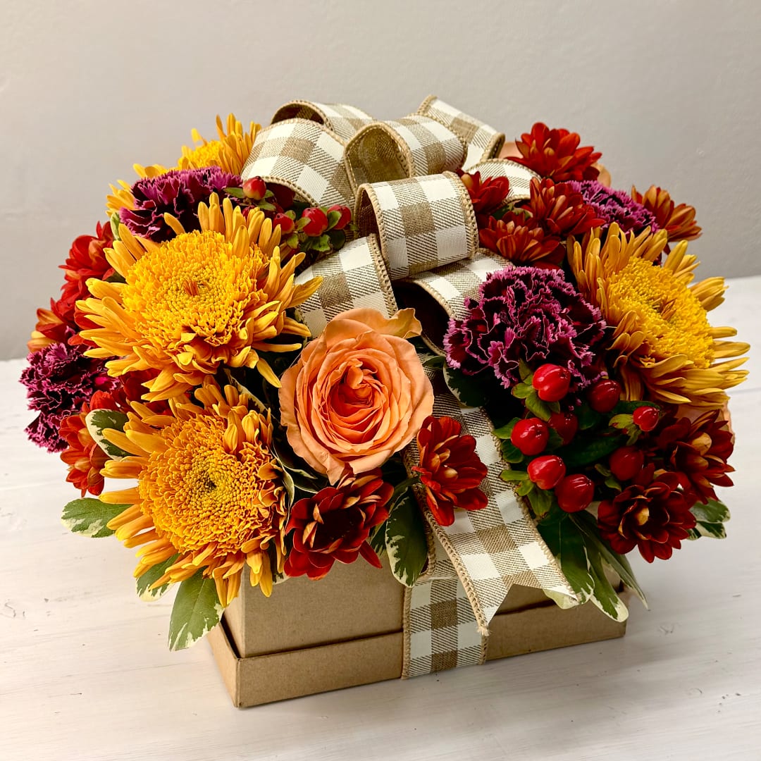 Flower arrangement in a gift box with a plaid ribbon bow