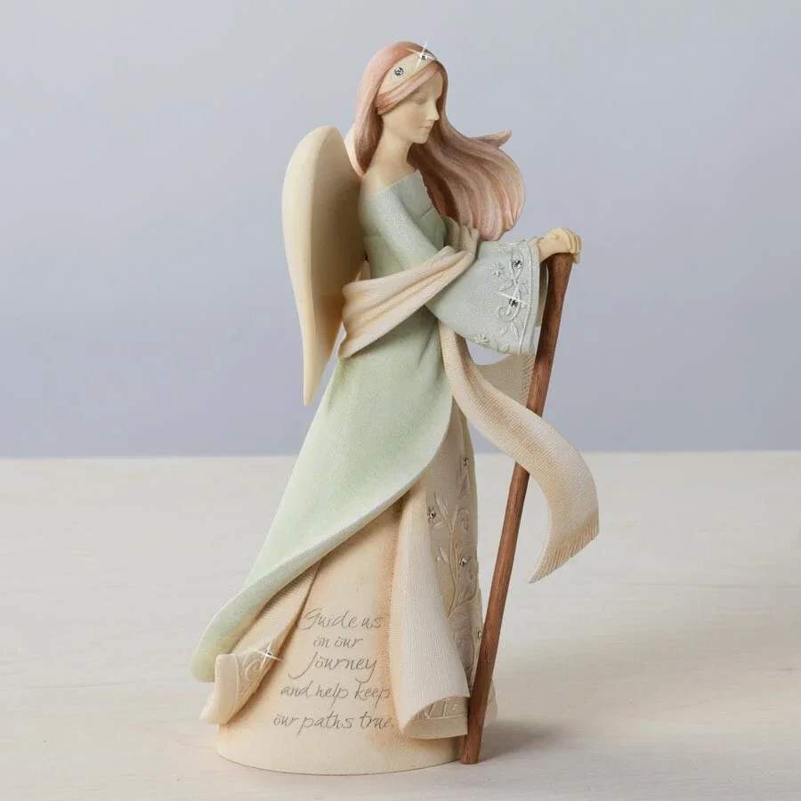 Angel figurine holding a staff, wearing a pale dress and scarf