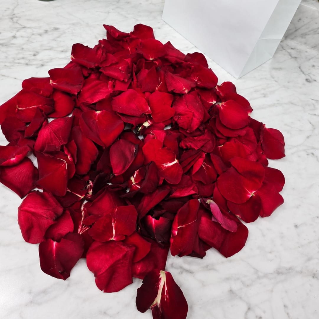 Pile of red rose petals on a marble surface