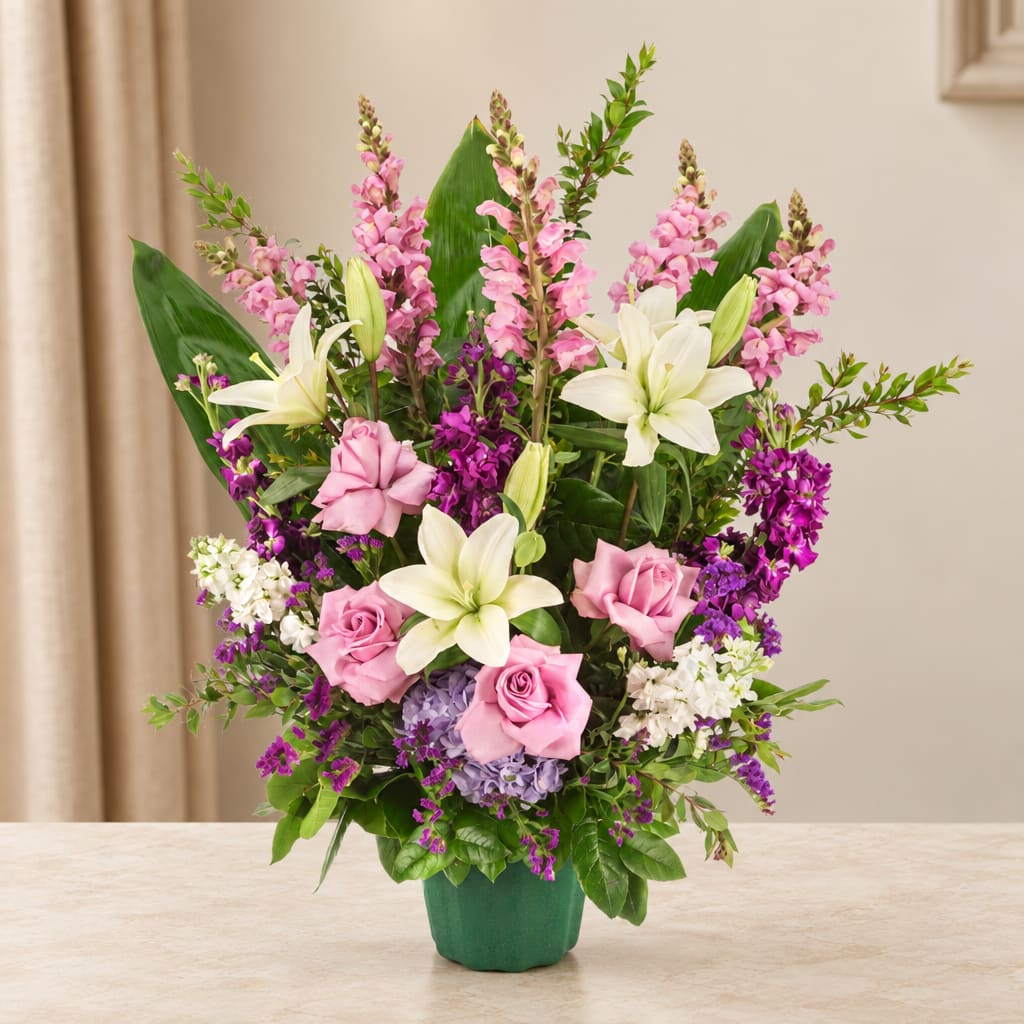 Pink roses and white lilies in a green vase