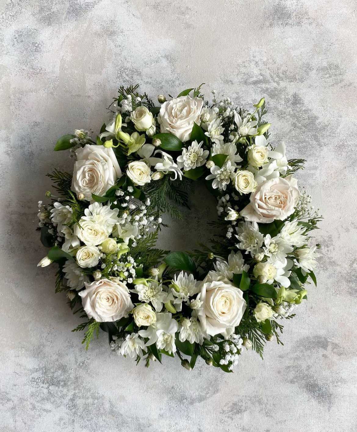 White floral wreath with roses and small white blooms