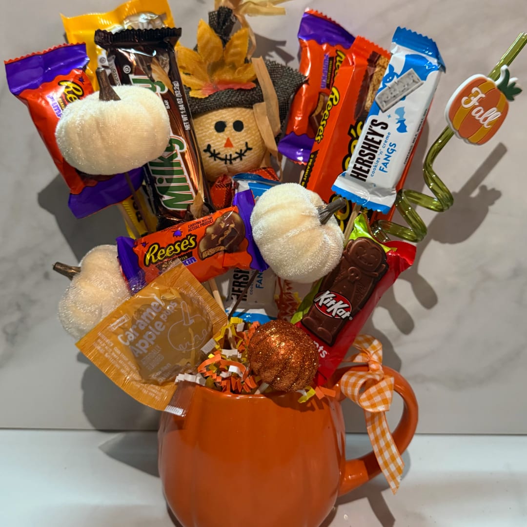 Candy bouquet in an orange mug with pumpkin decorations and ribbon