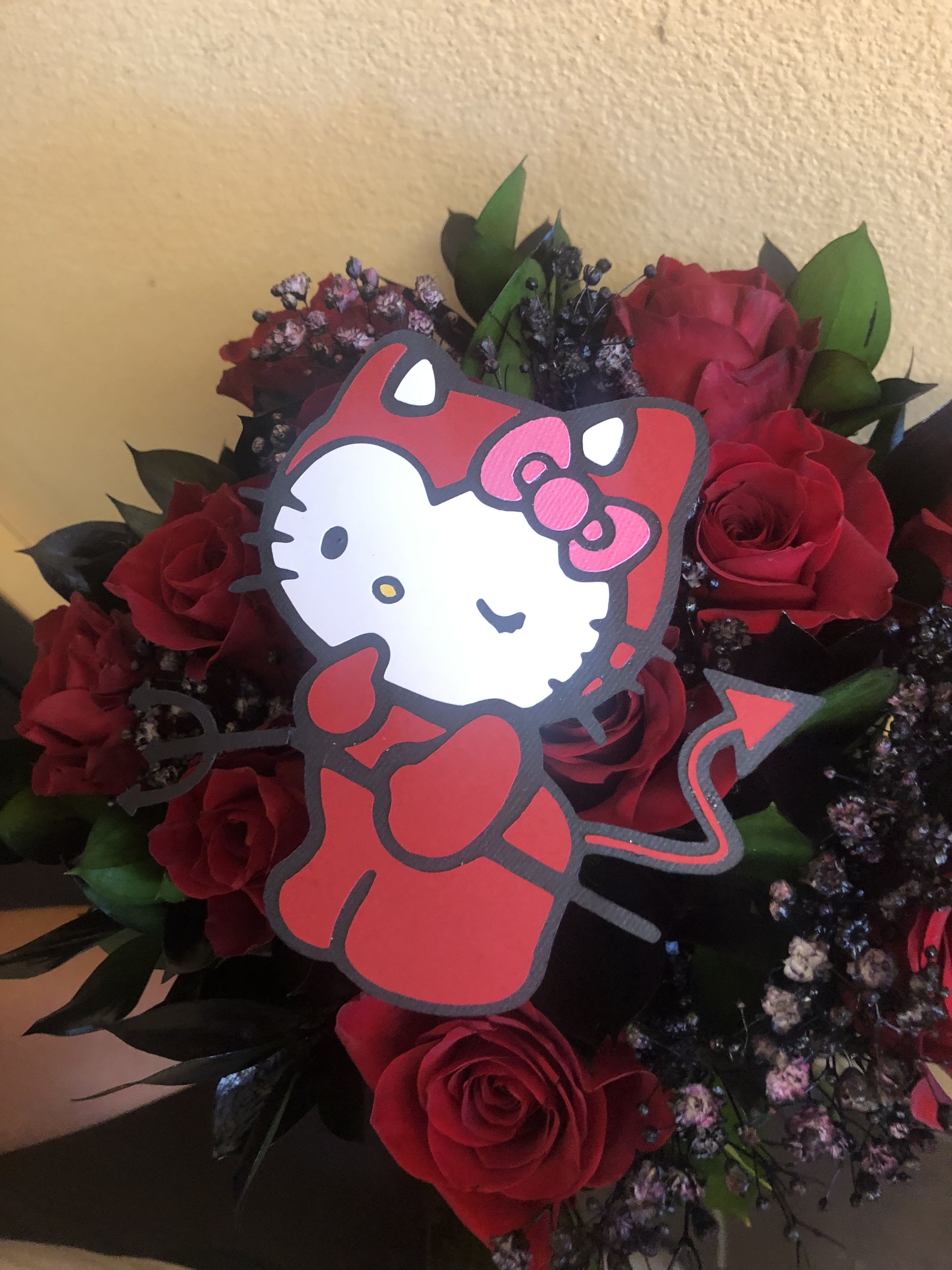HALLOWEEN WRAP WITH HELLO KITTY CUT OFF  - 12 RED ROSES WITH SPRAYED PAINTED BABY BREATH IN BLACK AND BLACK RUSCUS ALSO SPAY PAINTED WITH A HELLO KITTY DRESSES AS A LITTLE DEVIL CUT OFF (CUT OFF IS ABOUT 5 INCHES TALL)  INSERTED IN BETWEEN THE ROSES ALL WRAPPED IN KOREAN PAPER.   THIS DOES NOT COME IN A VASE.  IT'S A FLORAL WRAP.   ITS WRAPPED IN BLACK KOREAN PAPER.  STANDARD SIZE HAS 12 ROSES DELUXE SIZE HAS 18 ROSES PREMIUM SIZ HAS 24 ROSES
