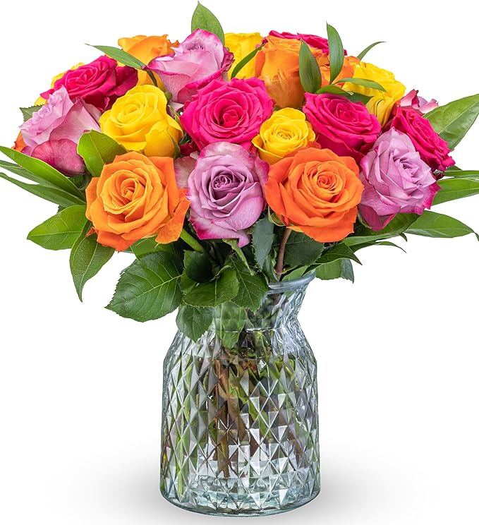 Mixed roses in bright pink, yellow, orange, and lavender in a glass vase