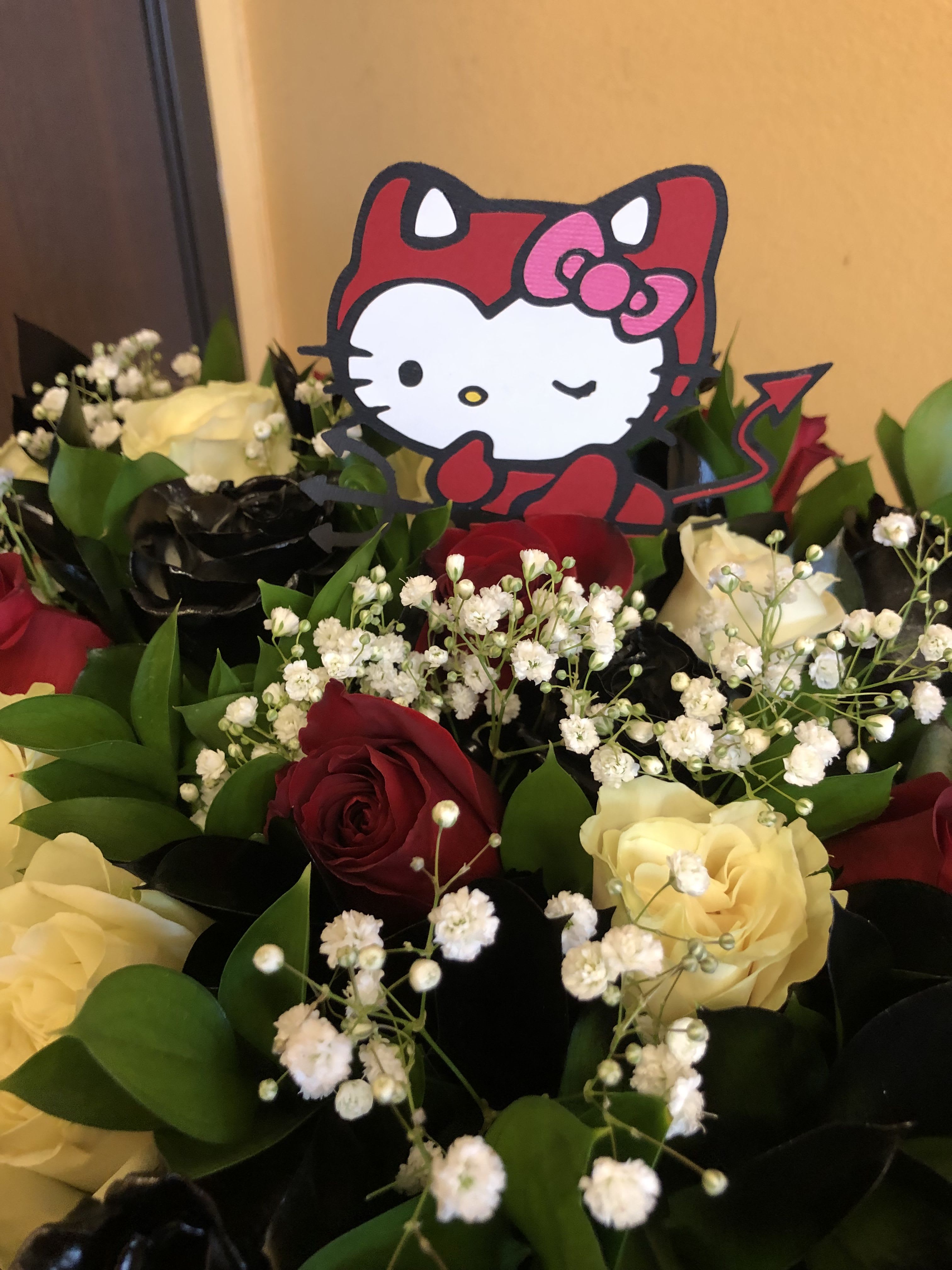 HALLOWEEN WRAP (HELLO KITTY DRESSED AS A LITTLE DEVIL) - 12 ROSES ( 4 WHITE ROSES, 4 SPRAY PAINTED BLACK ROSES, 4 RED ROSES) WITH BABY BREATH AND RUSCUS.  WE INSERT THE 5 INCH PAPER CUT OFF OF HELLO KITTY DRESSES AS A LITTLE DEVIL.  NOTE THIS DOES NOT COME IN A VASE.  WE WRAP THIS IN KOREAN BLACK PAPER.  STANDARD IS 12 ROSES DELUXE IS 18 ROSES PREMIUM IS 24 ROSES.