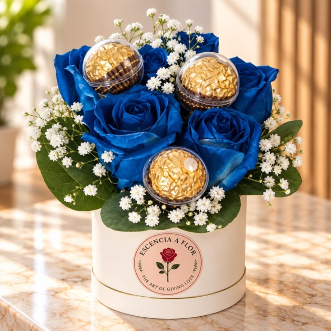 Blue roses with baby’s breath and gold-wrapped chocolates in a round box