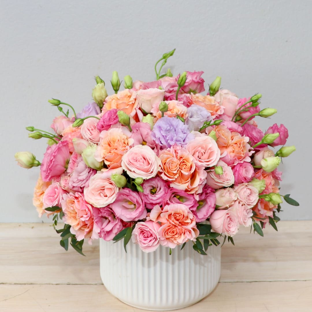 Pink and peach bouquet in a white ribbed vase