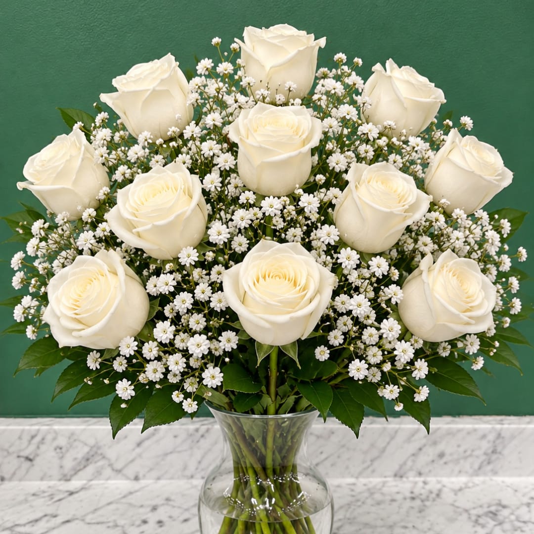 White roses and baby's breath in a clear glass vase