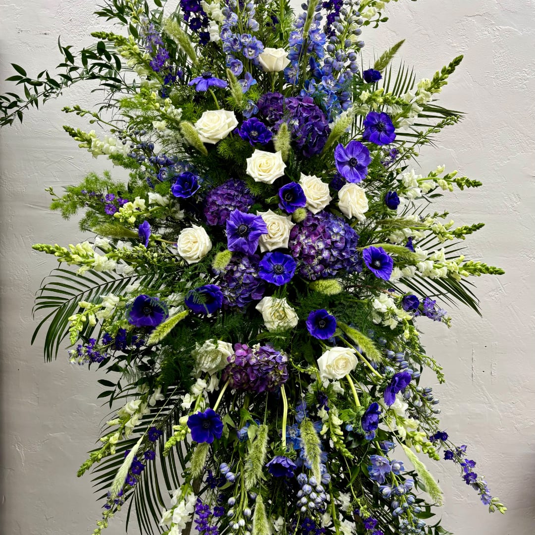 Tall floral spray with white roses, purple blooms, and blue flowers