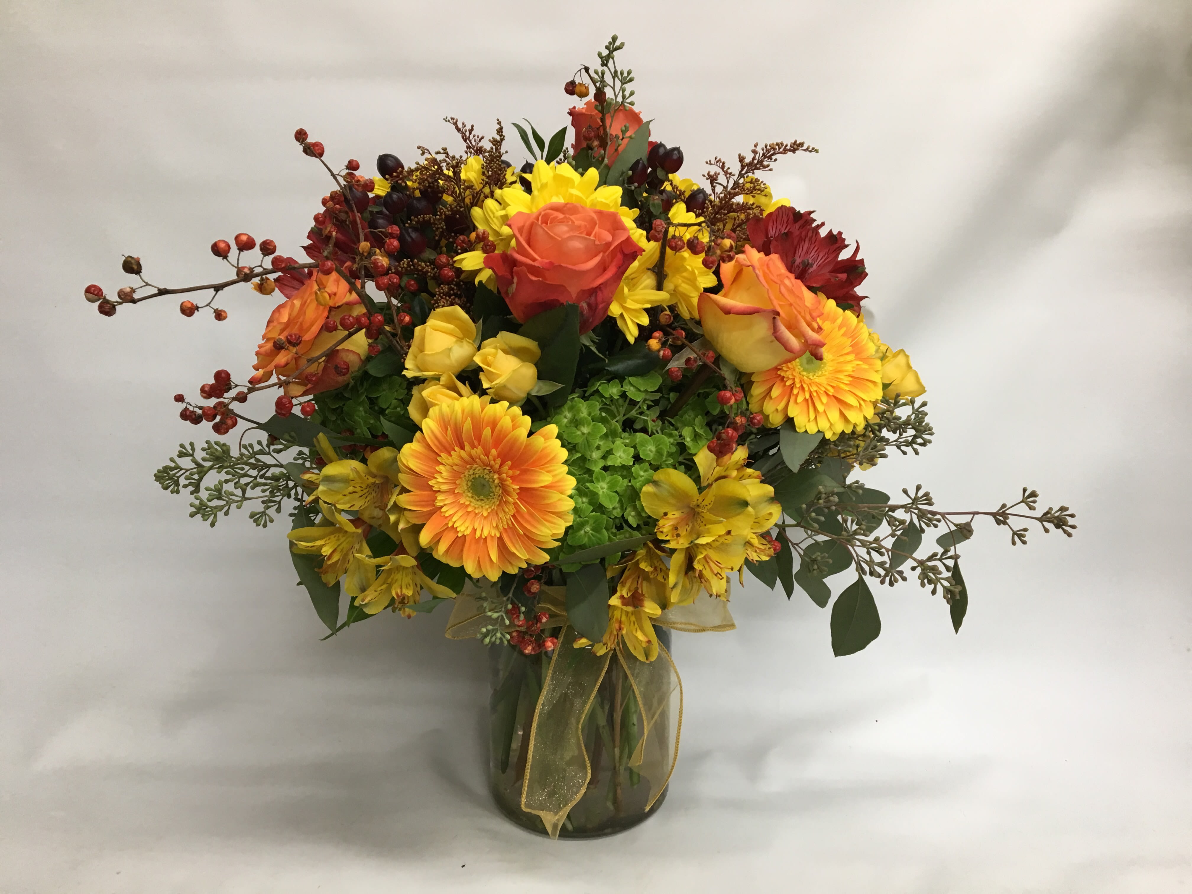 Mixed bouquet of yellow and orange flowers in a glass vase