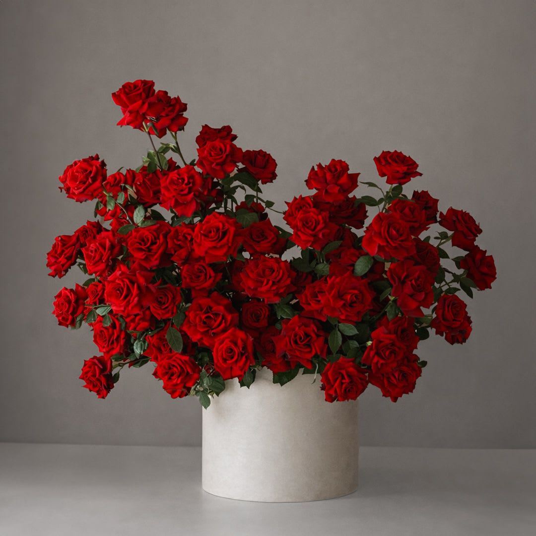 Large bouquet of red roses in a white cylindrical vase
