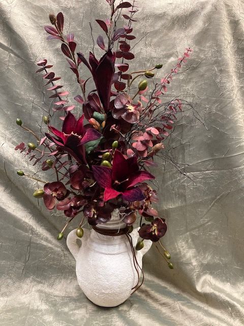 Deep burgundy floral arrangement in a white vase