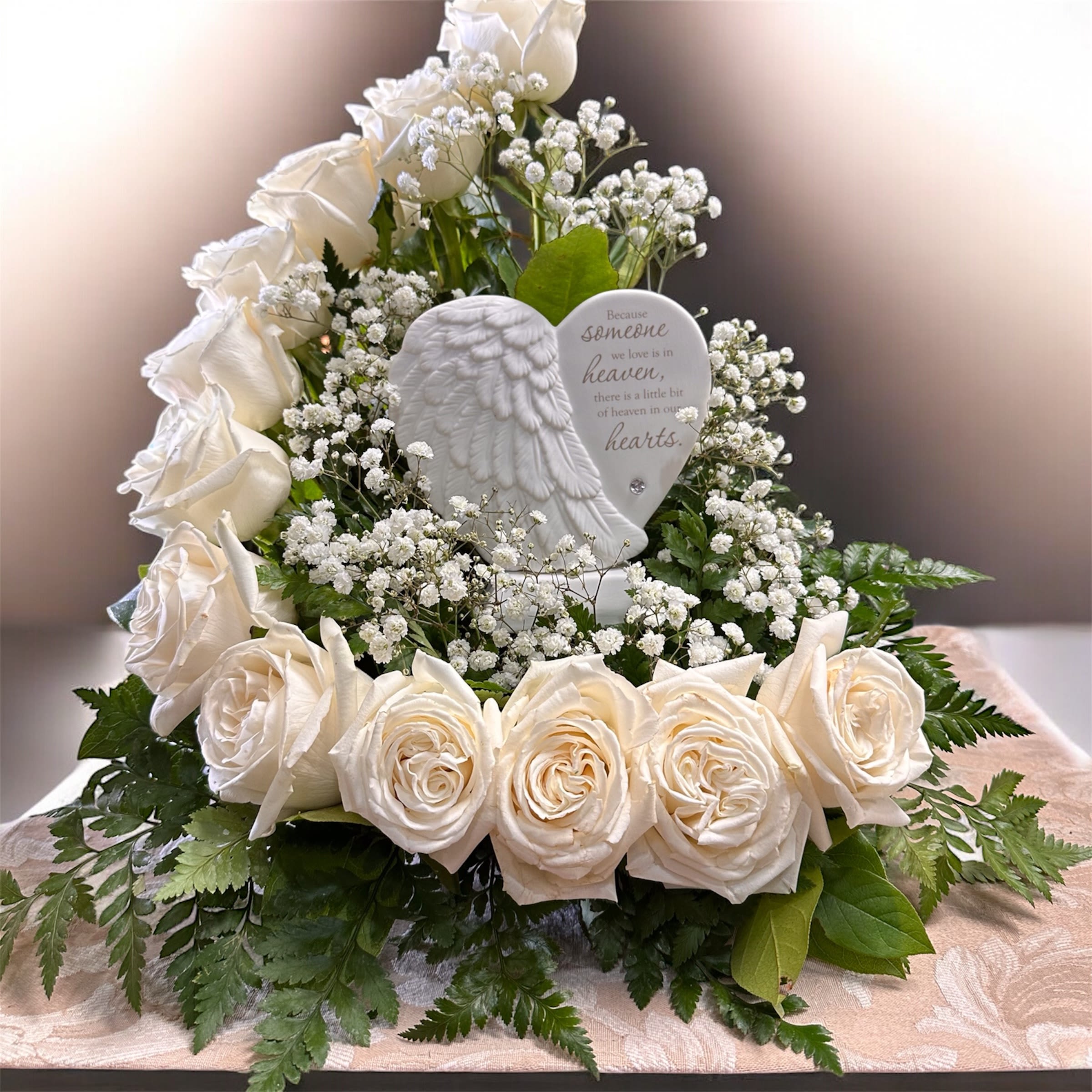 Hearts in Heaven Stairway to Heaven - White and green sympathy wreath of creamy roses and baby's breath surrounding a ceramic heart plaque with angel wing-serene, comforting tribute for remembrance.