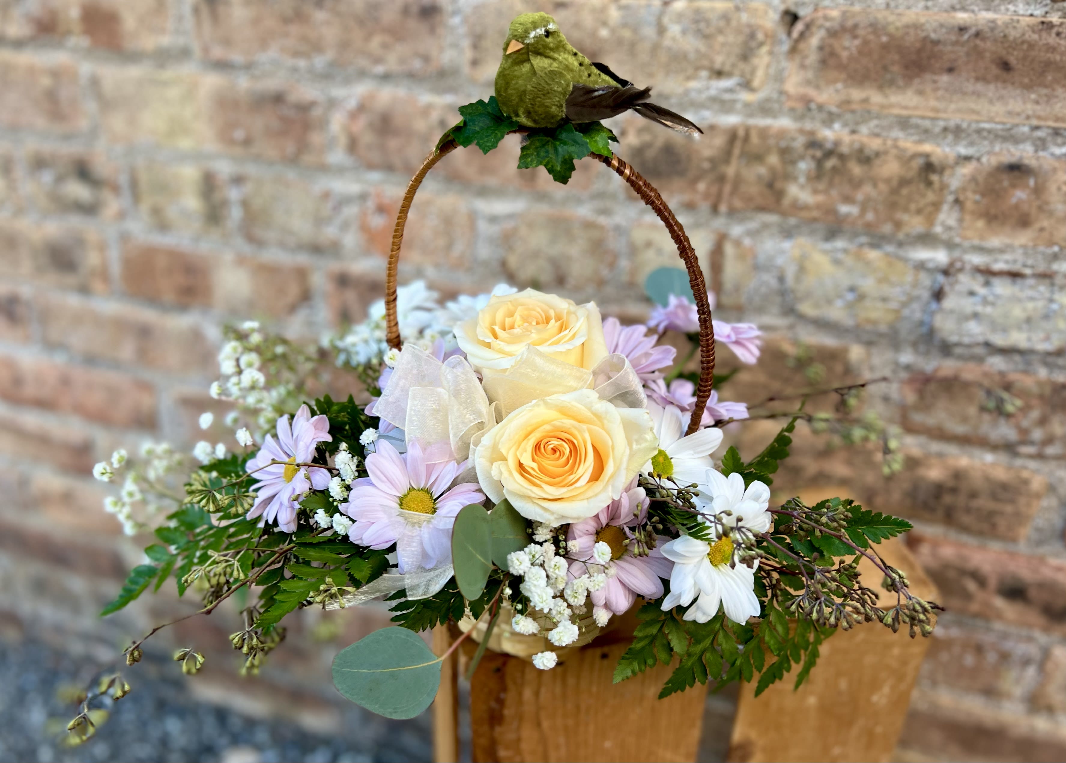 Basket arrangement with pale yellow roses and lavender daisies