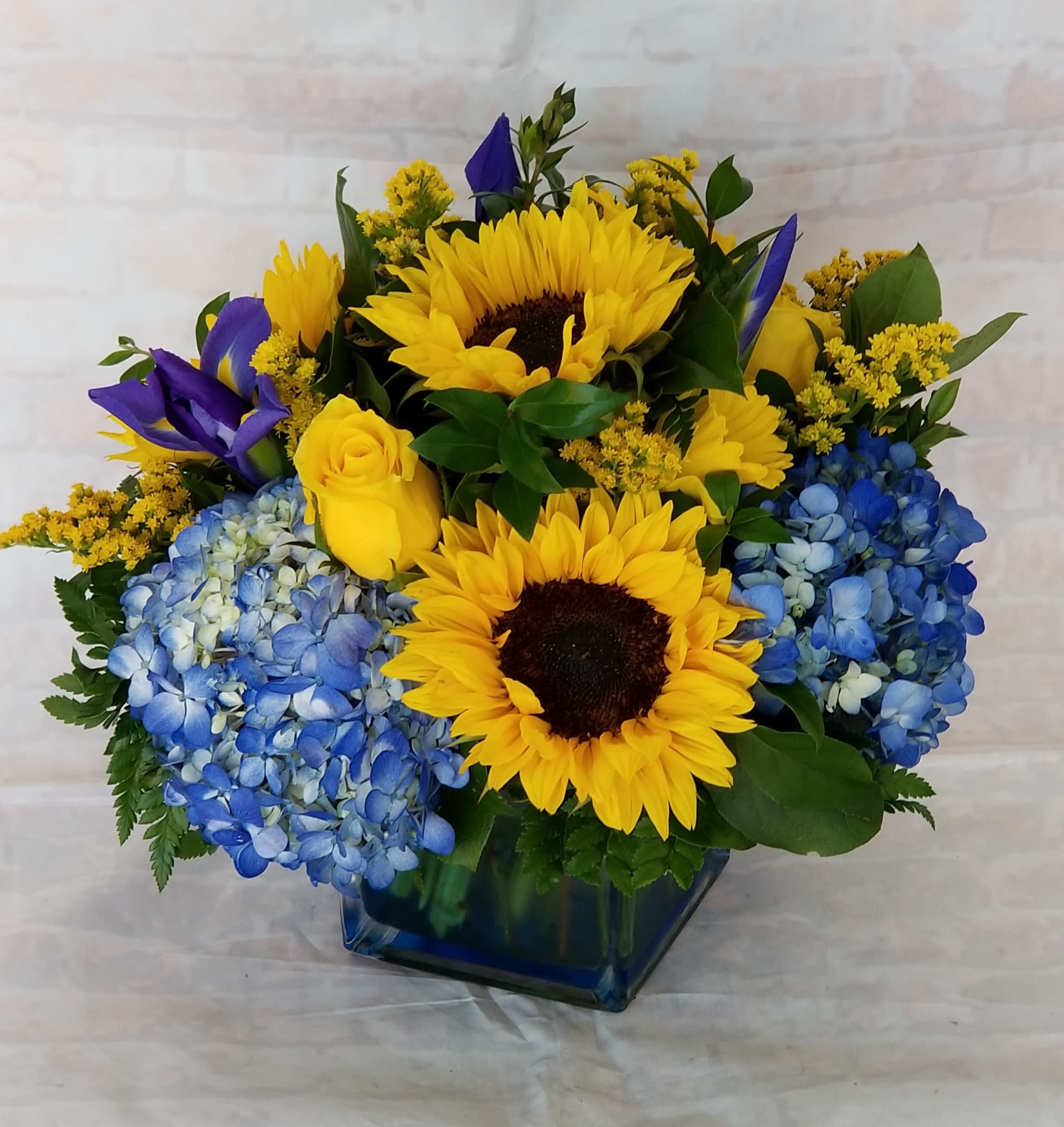 Graduation Celebration - Select this large cube arrangement packet with festive graduation blooms. Flowers include sunflowers, hydrangea, roses and Iris.