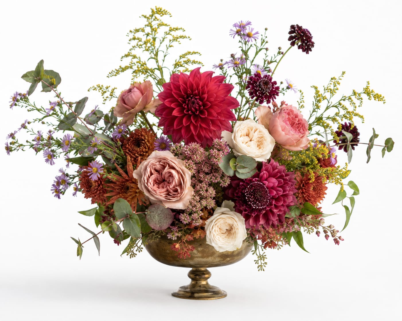 Mixed bouquet of pink, burgundy, and white flowers in a gold pedestal bowl